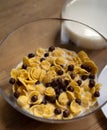 Healthy corn flakes with milk and chocolate balls in glass bowl on a wooden table. Quick breakfast concept. High angle Royalty Free Stock Photo