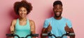 Healthy couple in teal tank tops giving thumbs up on soft colored background with space for text