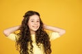 Healthy curls. Easy hairdo. Beauty supplies. Perfectly untangle curly hair. Pretty girl curly hair yellow background
