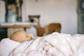 Healthy daytime sleep for the newborn. A baby in a baby cocoon sleeps in a room