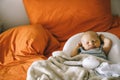 Healthy daytime sleep for the newborn. The baby is sleeping in the orthopedic Baby Cocoon on the bed