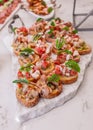 Healthy and delicious bruschetta served with tomatoes and marinated vegetables.