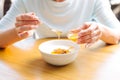 Female hands pouring honey to oatmeal