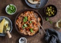 Healthy delicious lunch - spaghetti with tomato sauce and mussels on a wooden table, top view.