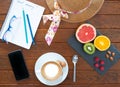 A healthy departure for a day in good shape. Rustic wooden table with a hot cappuccino and some citrus fruits, three small