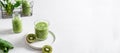 Healthy detox banner. Green smoothie with spinach, apple and kiwi in a glass with fresh ingredients on light background. Copy Royalty Free Stock Photo