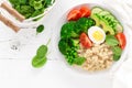 Healthy detox dish with egg, avocado, quinoa, spinach, fresh tomato, green peas and broccoli on white wooden background Royalty Free Stock Photo