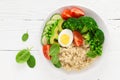 Healthy detox dish with egg, avocado, quinoa, spinach, fresh tomato, green peas and broccoli on white wooden background Royalty Free Stock Photo