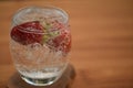 Healthy drink of sparkling water in a glass with fresh strawberries