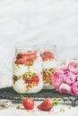 Healthy detox spring breakfast jars with pink raninkulus flowers Royalty Free Stock Photo