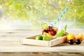 Healthy detox water, glass of cherry, orange and lime on wooden tray