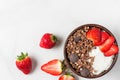 Healthy diet breakfast. bowl of oat chocolate granola with yogurt, fresh strawberries on white marble table Royalty Free Stock Photo
