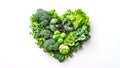 Heart consists of natural fresh raw green vegetables on white background