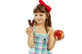 Healthy diet choices - little girl with apple and chocolate Royalty Free Stock Photo