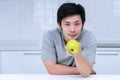 Healthy diet concept. smiling young man holding green fresh apple breakfast in his kitchen looking camera Royalty Free Stock Photo