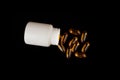 Healthy diet concept. Fish oil capsules with omega 3 and vitamin D in a plastic bottle on a black background.