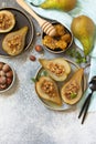 Healthy diet dessert. Baked pears with hazelnuts, honey and granola on a slate, stone or concrete background. Royalty Free Stock Photo