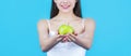 Healthy diet food. Woman with perfect smile holding apple, blue background. Woman eat green apple. Portrait of young Royalty Free Stock Photo