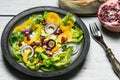 Healthy breakfast, fresh salad with the addition of purple onion and pomegranate seeds on white, wooden background