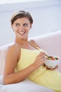 Healthy diet for her babys benefit. A relaxed pregnant woman enjoying a healthy salad while sitting on the couch. Royalty Free Stock Photo