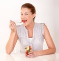 A healthy diet improves her day. A lovely young woman eating a healthy fruit salad. Royalty Free Stock Photo