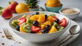 Healthy diet, light fresh fruit salad in a white bowl on a white background, strawberries and tropical fruits Royalty Free Stock Photo