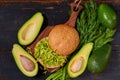 Healthy diet Mexican guacamole burger on the wooden board decorated with fresh herbs. Vegetarian green avocado sandwich Royalty Free Stock Photo