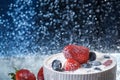 Milk splash close up of falling berries in a grey plate of milk. Strawberries and blueberries multivitamin cocktail. Healthy diet. Royalty Free Stock Photo