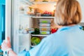 Healthy diet plan for weight loss, daily ready meal menu. Woman open fridge with lunch boxes cooked in advance and ready Royalty Free Stock Photo