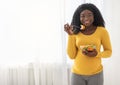 Happy mother pregnant black woman eating fresh salad at home Royalty Free Stock Photo