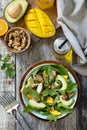 Healthy diet salad with turkey, grill arugula, mango, avocado and vinaigrette dressing on a rustic countertop. Top view flat lay