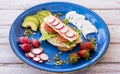 An healthy and dietetic sandwich with turkey meat tomatoes lettuce and radishes - appetizing snack accompanied by avocado and Royalty Free Stock Photo