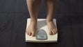 Healthy dieting, girl standing on bathroom scales to check weight, normal index Royalty Free Stock Photo