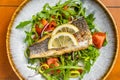 Healthy diner with sea bass fillet and vegetable salad, seabass fish. Orange background. Top view Royalty Free Stock Photo