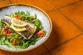 Healthy diner with sea bass fillet and vegetable salad, seabass fish. Orange background. Top view. Copy space Royalty Free Stock Photo