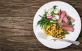 Bowl lunch with grilled beef steak and quinoa, corn, cucumber, radish and arugula