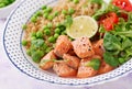 Slices of grilled salmon, quinoa, green peas, tomato, lime and lettuce leaves Royalty Free Stock Photo