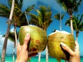 Healthy drink on a Caribbean beach. Pineapple and coconut handheld on the beach