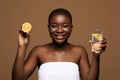 Healthy Drink. Smiling black lady holding glass of water and lemon half Royalty Free Stock Photo