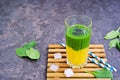 A healthy drink, a two-layer smoothie with fresh spinach and ripe mango in a tall glass