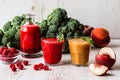 Healthy drinks. raspberry fresh smoothie in glass and bottle and peach juice on white wooden background Royalty Free Stock Photo