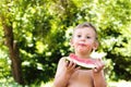 Boy eats watermelon outdoors