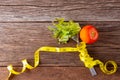 Healthy eating concept. Fork and vegetable with measure tape and fresh tomato on wooden desk. Top view and Copy space Royalty Free Stock Photo