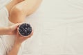 Healthy eating concept. Woman having blueberries in bed. Royalty Free Stock Photo