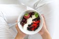 Healthy eating concept. Women`s hands holding bowl with cottage cheese with cream, strawberry, cherry, gooseberry and blueberry Royalty Free Stock Photo