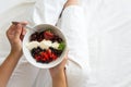 Healthy eating concept. Women`s hands holding bowl with cottage cheese with cream, strawberry, cherry, gooseberry and blueberry Royalty Free Stock Photo