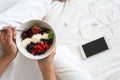 Healthy eating concept. Women`s hands holding bowl with cottage cheese with cream, strawberry, cherry, gooseberry and blueberry Royalty Free Stock Photo