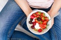 Healthy eating concept. Women`s hands holding bowl with muesli, yogurt, strawberry and cherry. Top view. Lifestyle Royalty Free Stock Photo