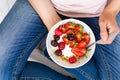 Healthy eating concept. Women`s hands holding bowl with muesli, yogurt, strawberry and cherry. Top view. Lifestyle Royalty Free Stock Photo