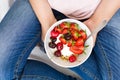 Healthy eating concept. Women`s hands holding bowl with muesli, yogurt, strawberry and cherry. Top view. Lifestyle Royalty Free Stock Photo
